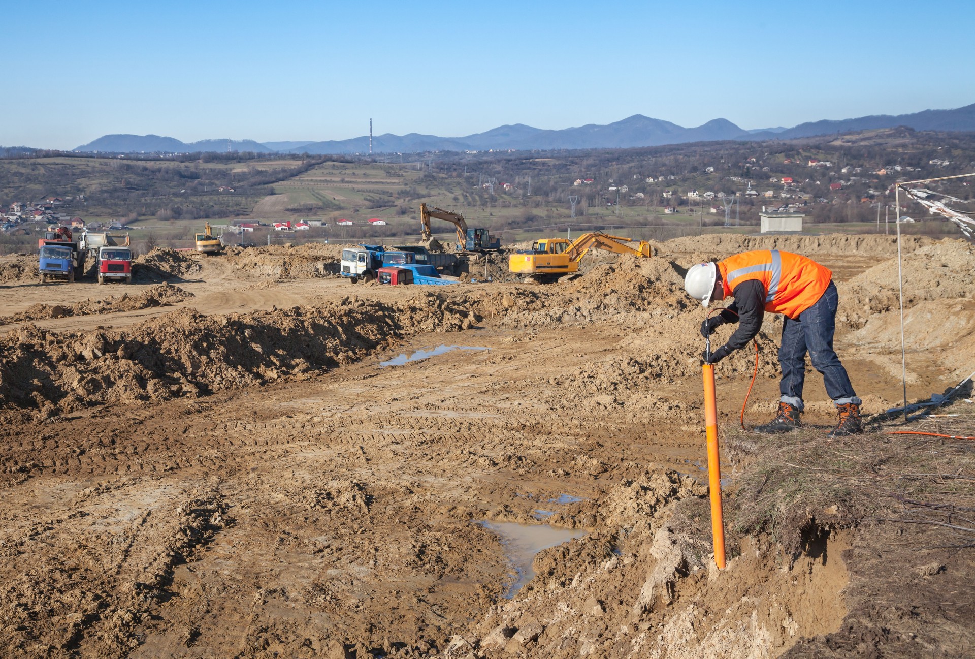 Construction trucks and engineer at dig site